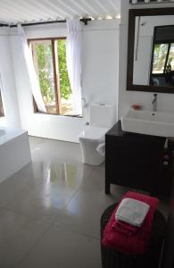 a bathroom with a sink and a toilet and a mirror at Azeer's in Arugam Bay +10 photos