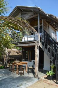 a wooden house with a table and a wooden table at Azeer's in Arugam Bay