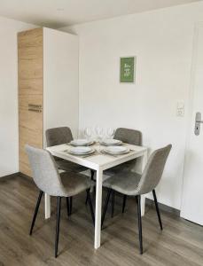 a white dining room table with four chairs and a white table at Cozy Apartment with Terrace & Free Parking in Würzburg