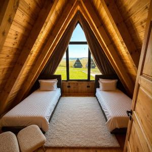 two beds in a room with a window at Monte Casa Žabljak in Žabljak