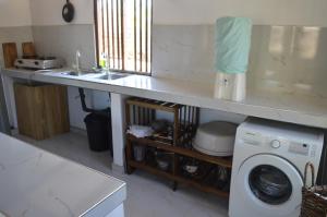 a kitchen with a sink and a washing machine at Azeer's in Arugam Bay
