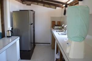 a kitchen with a refrigerator and a sink at Azeer's in Arugam Bay