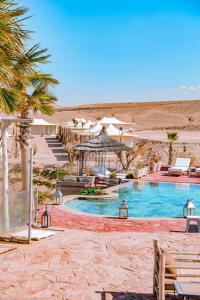 a swimming pool with umbrellas and a resort at Yes We Camp Agafay Luxury Khaïma & Restaurant - Spa in El Karia