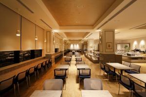 a restaurant with tables and chairs and a bar at Hotel Monte Hermana Fukuoka in Fukuoka