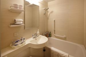 a white bathroom with a sink and a bath tub at Hotel Monte Hermana Fukuoka in Fukuoka +46 photos