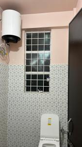a bathroom with a toilet and a window at Serenity View Stay in Shillong +17 photos