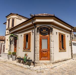 an old building with a wooden door on a street at Orama Suite & Spa in Korçë
