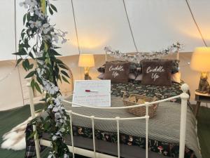 a bed with pillows and a sign on it at Woodview Caravan Site in Church Leigh