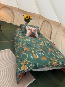 a bed in a tent with a cat laying on it at Woodview Caravan Site in Church Leigh