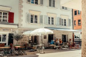 a group of people sitting at tables outside a building at Retro-Chic Wohnung in der Bregenzer Fußgängerzone in Bregenz