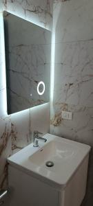 a white bathroom with a sink and a mirror at Hotel LULI in Baks-Rrjoll +14 photos