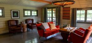 a living room with a couch and chairs and a table at Grindal Salmon Lodge in Rennebu