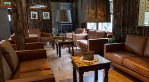 a living room with leather couches and a table at Grindal Salmon Lodge in Rennebu