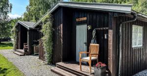 a wooden shed with a chair sitting on the steps at Grindal Salmon Lodge in Rennebu