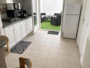 a kitchen with a white refrigerator and a table at l 'Escapade Atlantique in Saint-Nazaire
