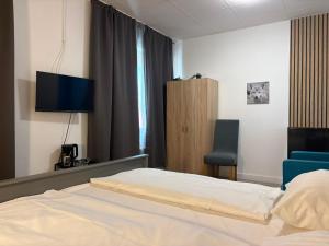 a hotel room with a bed and a chair at Art Rock Airport in Cologne