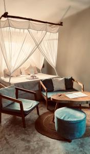 a living room with a bed and a table and chairs at Zen Boutique Retreat & Resort in Jambiani +97 photos
