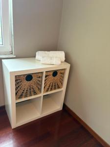 a white cabinet with two towels on top of it at Lar de Luz in Palas de Rei