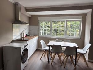 a kitchen with a table and chairs and a kitchen with a washer at Lar de Luz in Palas de Rei