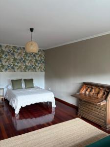 a bedroom with a bed and a dresser in it at Lar de Luz in Palas de Rei
