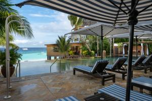 ein Pool mit Liegestühlen und Sonnenschirmen und das Meer in der Unterkunft Z Hotel & Z2 Hotel in Nungwi