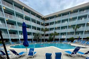 a large hotel with chairs and a swimming pool at Sandy Toes Getaway in Hilton Head Island