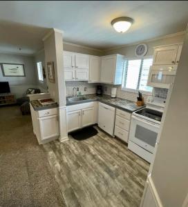 a kitchen with white cabinets and white appliances at Sandy Toes Getaway in Hilton Head Island