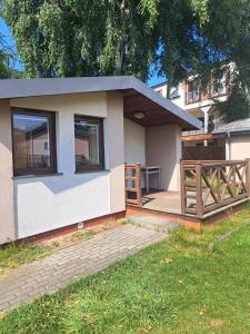 a small house with a porch and a wooden fence at OW Viva in Jantar