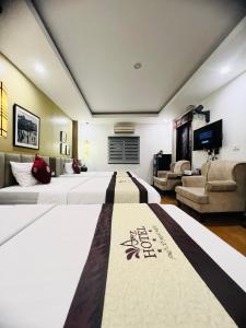a hotel room with two beds and a living room at Art Hotel Ha Noi in Hanoi
