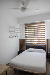 a bedroom with a bed and a window with blinds at Next Stop Atocha in Madrid
