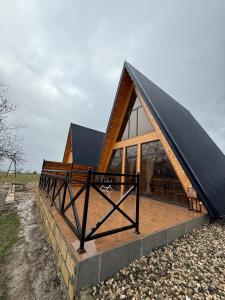 a frame house with a black roof on a stone wall at Green zone Aframe in Qusar