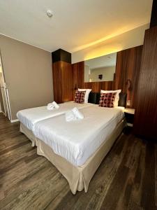 a bedroom with a large white bed in a room at Gosset Hotel in Groot-Bijgaarden +16 photos