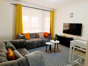 a living room with a couch and a flat screen tv at Mura suites homes in Nakuru
