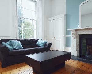 a living room with a couch and a coffee table at No 13 Georgian Shared House - By Clifton Short Lets in Bristol