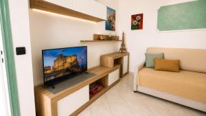a living room with a flat screen tv on a wall at Hotel Aragonese Ischia in Ischia Town