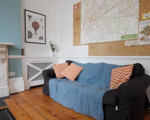 a living room with a blue couch with pillows on it at No 13 Georgian Shared House - By Clifton Short Lets in Bristol