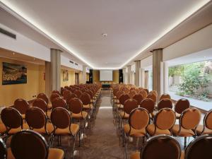 an empty room with rows of chairs in a building at Acacia Resort in Campofelice di Roccella +99 photos