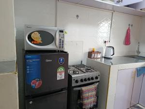 a microwave sitting on top of a stove in a kitchen at Mura suites homes in Nakuru