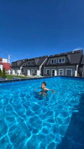 a man swimming in a large swimming pool at Przystań Dziwnówek in Dziwnówek