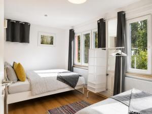 un dormitorio con dos camas y dos ventanas en The garden flat, en Luxemburgo 2 fotos más