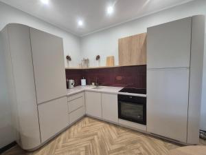 a kitchen with white cabinets and a refrigerator at Apartamenty u Justyny - Ametyst in Borne Sulinowo