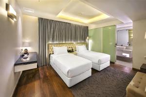 ein Hotelzimmer mit zwei Betten und einer Couch in der Unterkunft Grace21 Runway Hotel in Dhaka + 34 Fotos