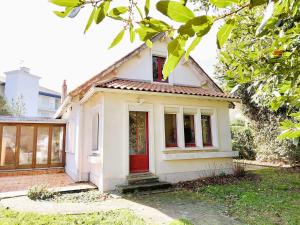a small white house with a red door at Phare - SAINT HILAIRE DE RIEZ in Saint-Hilaire-de-Riez