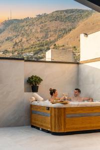 a man and a woman sitting in a bath tub at Antiche Cantine Bed & Breakfast in Alcamo