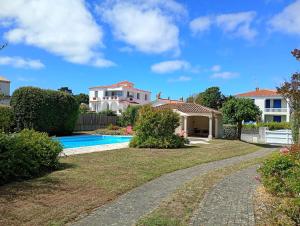 a villa with a swimming pool and a house at Phare - SAINT HILAIRE DE RIEZ in Saint-Hilaire-de-Riez