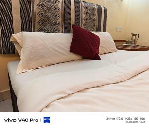 a bed with two pillows on top of it at Hotel HLD Matheran in Matheran