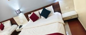 a bedroom with a large bed with pillows at Hotel HLD Matheran in Matheran +4 photos