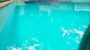 a swimming pool with blue water in it at Hotel HLD Matheran in Matheran