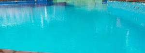 a blue body of water with a brick wall at Hotel HLD Matheran in Matheran
