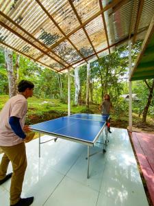 a man and a woman playing a ping pong table at Reserva Natural Tucuchira in Santa Sofía
